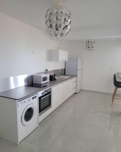 a kitchen with a washing machine and a microwave at Hello Guyane(3), Suite Prestige Premium, 5 étoiles in Cayenne