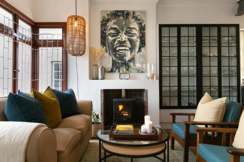 a living room with a couch and a fireplace at La Maison On Main Self-Catering Villa in Paarl