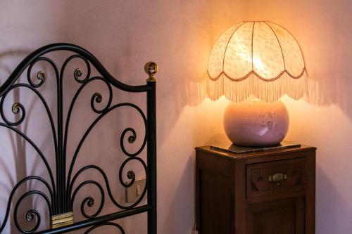 a lamp on a night stand next to a bed at Agriturismo Malpensata in Radda in Chianti