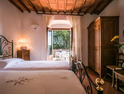a bedroom with two beds and a window at Agriturismo Malpensata in Radda in Chianti