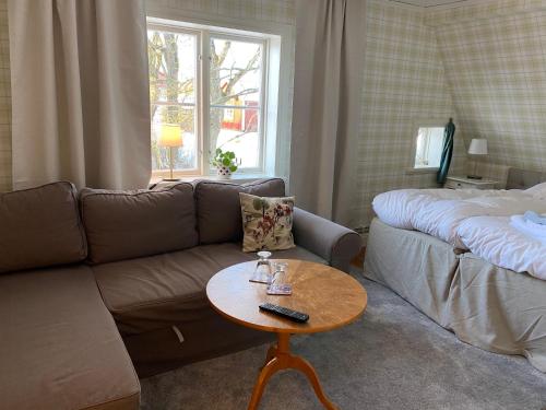 - un salon avec un canapé et une table dans l'établissement Bjälbo Gästhus B&B, à Skänninge