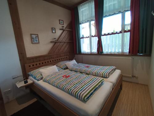 a small bed in a room with a window at Fasslreiter in Achenkirch