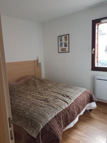 a bedroom with a bed in a white room at Bel Appartement 2 ch Les Jardins de Ramel in Luchon