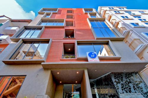 a tall building with windows and a blue sign on it at Zip By Spree Hotels Brookefield in Bengaluru