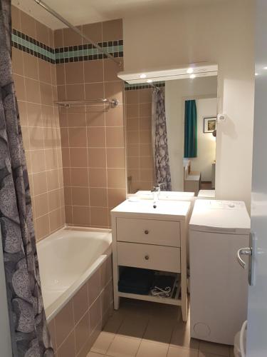 a bathroom with a sink and a tub and a toilet at Bel Appartement 2 ch Les Jardins de Ramel in Luchon