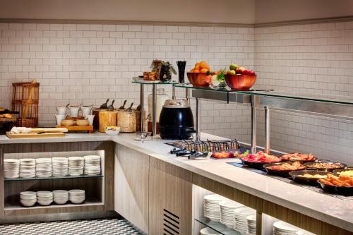 a kitchen with food on a counter in a restaurant at Leonardo Hotel Manchester Piccadilly in Manchester