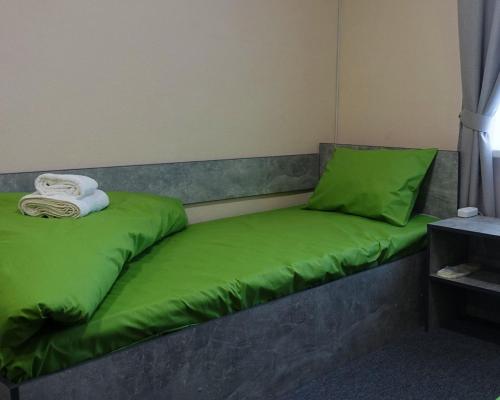 a bed with green pillows on top of it at Green cost in Boryspilʼ