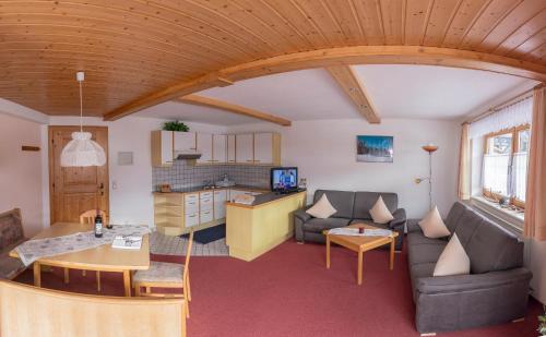 a living room with a couch and a kitchen at BergQuell in Tannheim