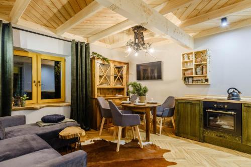 a living room with a couch and a table at Apartamenty Willa Olsza - wood house & mountain view in Zakopane