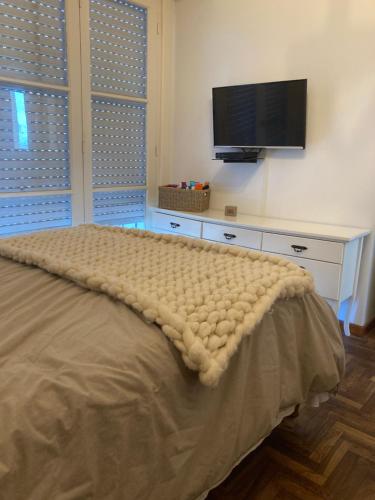 um quarto com uma cama e uma televisão de ecrã plano em Departamento en PLAYA GRANDE em Mar del Plata
