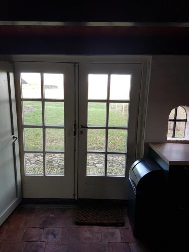 a room with two french doors with windows at Âlde Bakhûs in Sondel