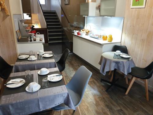 une salle à manger avec deux tables et des chaises ainsi qu'une cuisine dans l'établissement Hotel Le Splendid, à Troyes