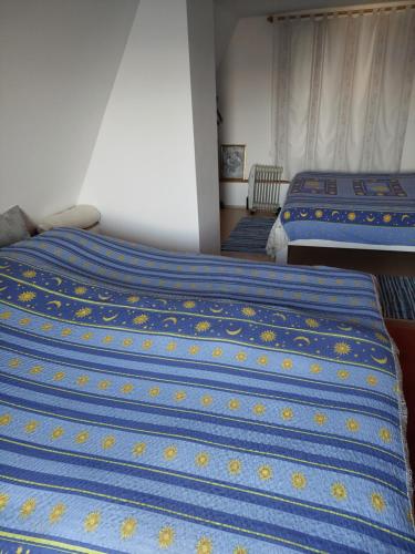 two beds in a room with blue and yellow sheets at Holiday Home Amila in Visoko