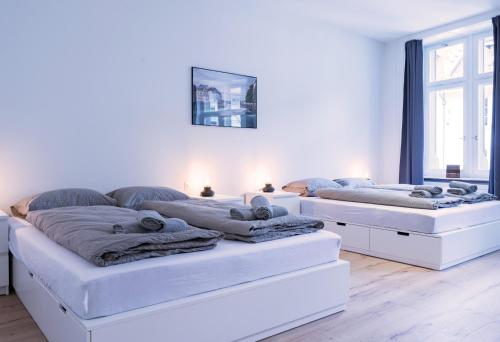 two beds in a white room with towels on them at HITrental Zur Metzgern Apartments in Luzern