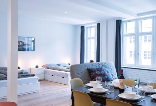 a living room with a table and a couch at HITrental Zur Metzgern Apartments in Luzern