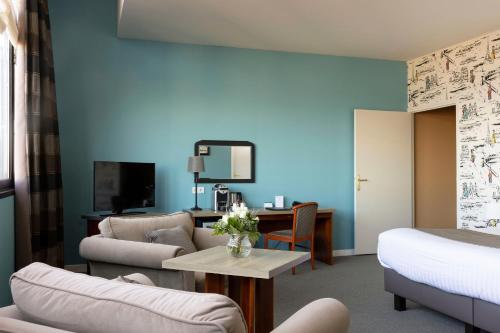 - un salon avec un canapé et une table dans l'établissement Best Western Hôtel Hermitage, à Montreuil-sur-Mer