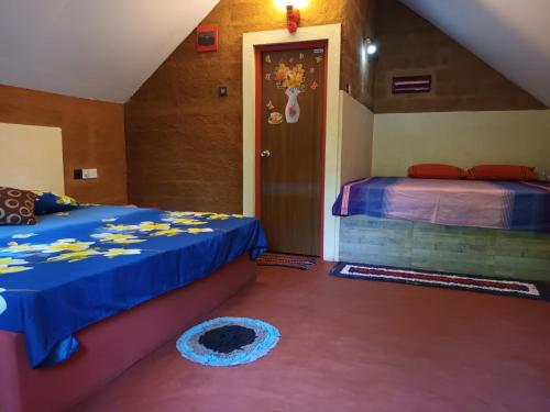 a bedroom with two beds and a door to a room at By The C' Cabanas in Hikkaduwa