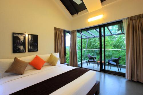 a bedroom with a bed and a large window at Tea Terrain Resorts & Spa in Vagamon