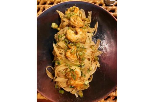a plate of food with shrimp and onions at Casa Canoa Camocim in Camocim