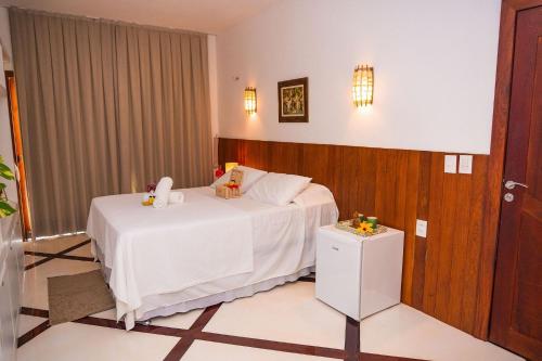 a hotel room with a bed with a white blanket at Casa Canoa Camocim in Camocim