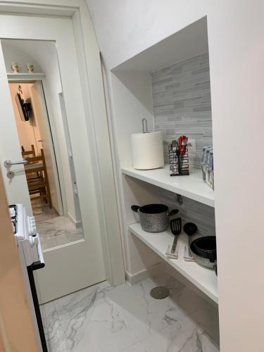 baño con estantes blancos y espejo en A cas e Nanninell, en Nápoles