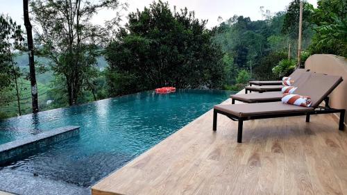 a chair sitting next to a pool of water at Tea Terrain Resorts & Spa in Vagamon