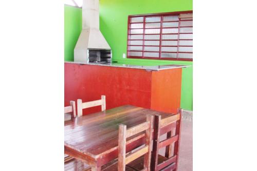 comedor con mesa de madera y paredes verdes en Pousada Fortaleza São Thomé, en São Thomé das Letras