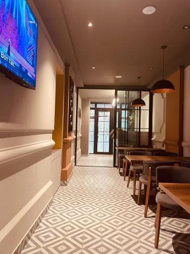 a dining room with tables and a tv on the wall at Eleven Hotel Baku in Baku