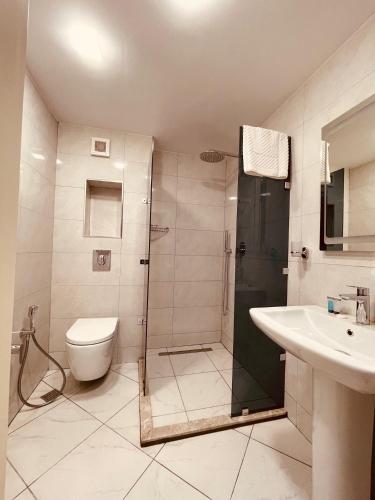a bathroom with a shower and a toilet and a sink at Eleven Hotel Baku in Baku