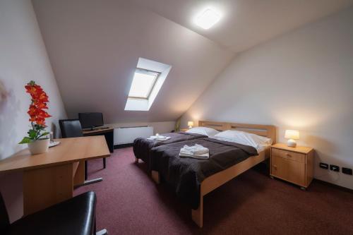 a bedroom with a bed and a desk and a computer at Hotel Astory Plzeň in Plzeň