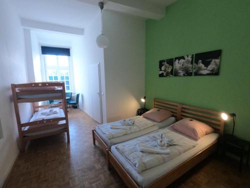 two beds in a room with a green wall at Hotel Schloss Walbeck in Geldern