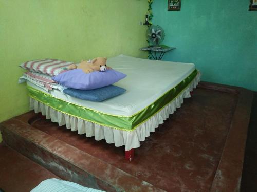 a bed with a teddy bear laying on top of it at Hideaway Resort in Maraat
