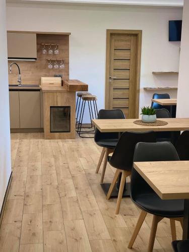a kitchen and dining room with wooden floors and tables at Penzion Pod Kaštanem in Nedakonitz