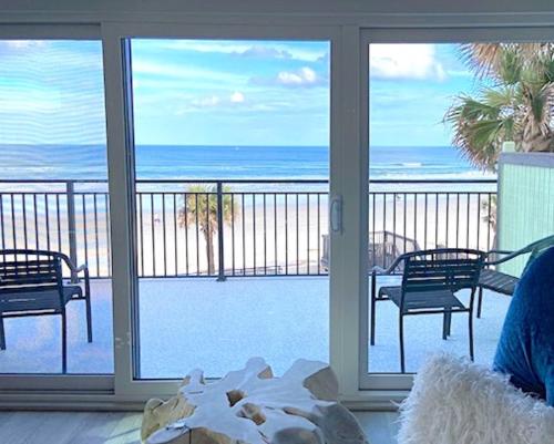 a room with a balcony with a view of the ocean at Organic Beach Retreat in Daytona Beach