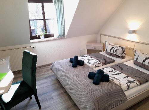 a bedroom with two beds and a desk and a table at Hotel Zum Postkutscher in Cottbus