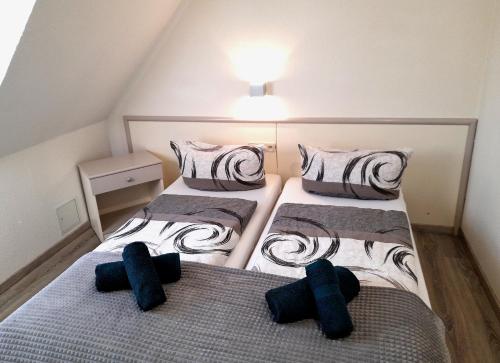 - 2 lits dans une petite chambre avec des oreillers noirs dans l'établissement Hotel Zum Postkutscher, à Cottbus