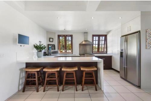 a kitchen with a large island with bar stools at Homestead on the Range - Sleeps 12 in The Range
