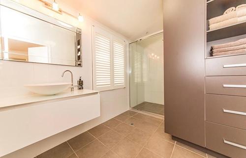 a bathroom with a sink and a glass shower at Homestead on the Range - Sleeps 12 in The Range