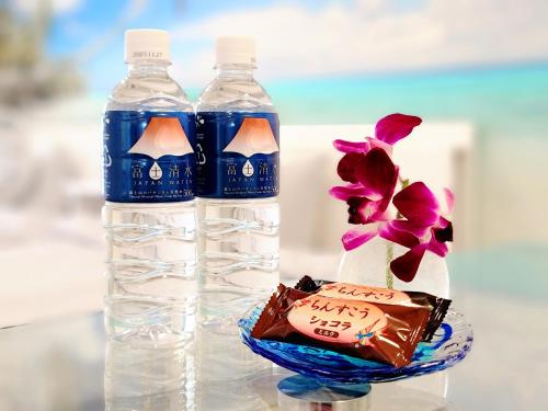 two bottles of water and a flower in a bowl at "徹底清潔のゆったり64平米2LDK, 人気のリゾートタウン北谷で暮らすように過ごす, 高速ICまで車で3分, 沖縄アリーナまで徒歩圏内" Villa Blu Okinawa Chatan 3-2 ヴィラブルー沖縄北谷3-2 in Chatan