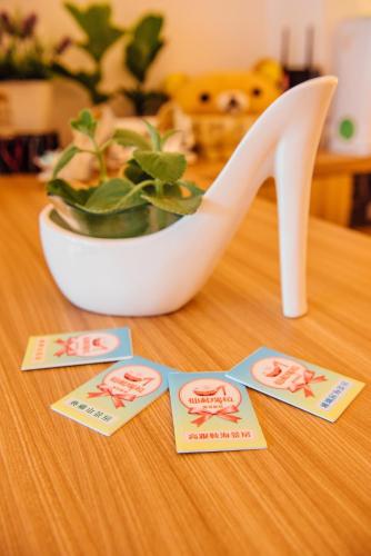 a white high heel shoe and a potted plant on a table at 墾丁后灣仙杜瑞拉海景旅宿 in Checheng
