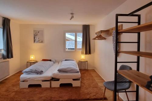 twee bedden in een kamer met een ladder en een stapelbed bij Falke 2nd Floor in Saas-Fee
