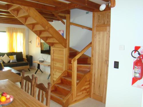 a wooden staircase in a living room with a table at Apart LAR DEL PEHUEN in Villa Pehuenia