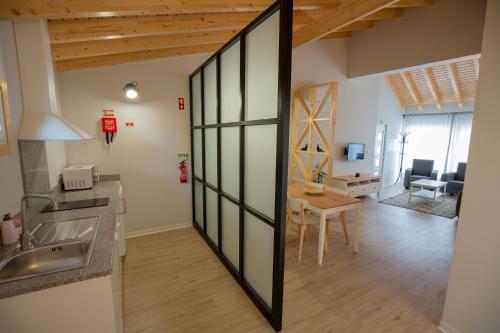 een keuken en een woonkamer met een glazen schuifdeur bij Casa dos Gatos in Lourinhã