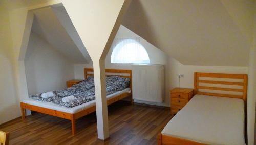 a bedroom with two beds and a window at Pajkos Póni Vendégház in Miskolc