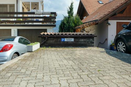 ein Auto, das neben einem Haus mit einer steinernen Einfahrt geparkt ist in der Unterkunft Luna in Thun