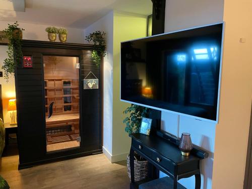 ein Wohnzimmer mit einem großen Flachbild-TV an der Wand in der Unterkunft Jungle Stay in a Hidden Paradise in Zwijndrecht
