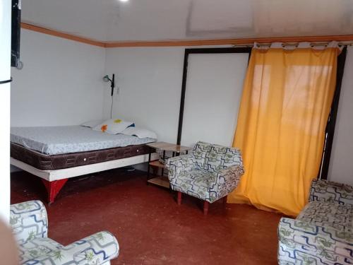 a room with a bed and two chairs and a table at Hideaway Resort Victoria secret hideaway resort in Maraat