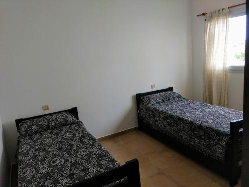 een slaapkamer met 2 bedden en een raam bij Alquileres Temporarios Villa María in Villa María