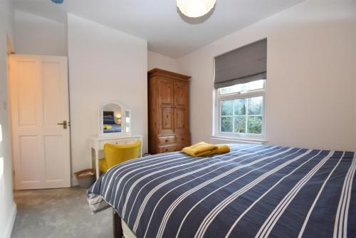 une chambre avec un lit bleu et blanc et une fenêtre dans l'établissement 4 Landgate Cottages, à Winchelsea