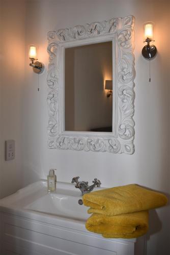 a bathroom with a mirror and a sink at 4 Landgate Cottages in Winchelsea